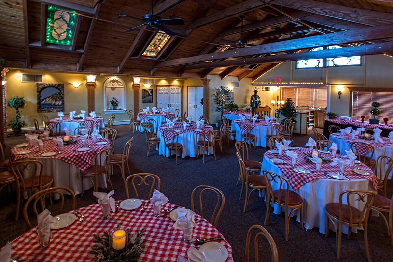 Private dining room with many set tables with red and white checkered table clothes