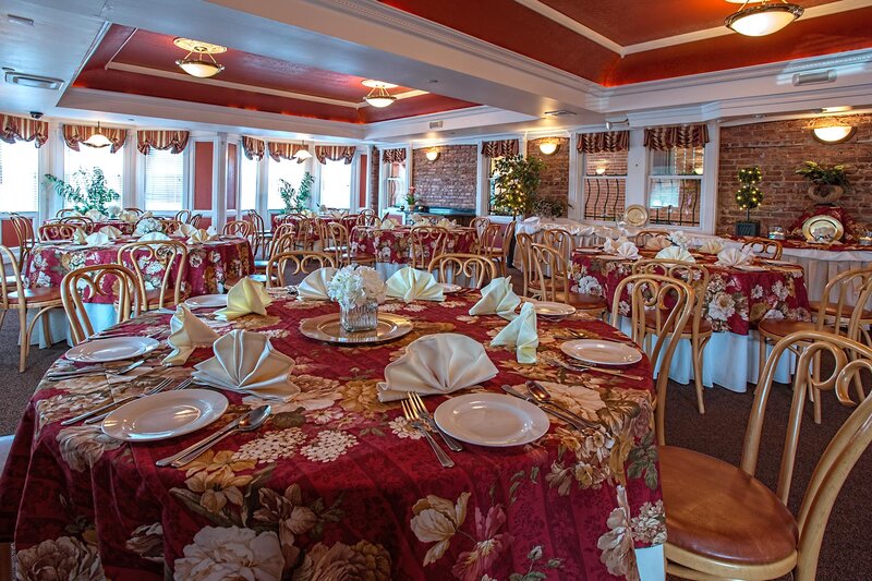 Banquet room with multiple set tables with red table cloths